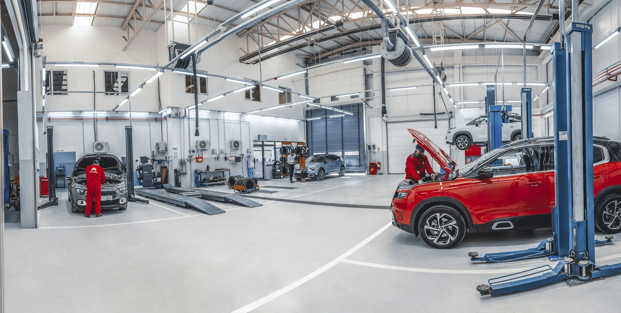 Wide view of a bright repair shop with several lifts